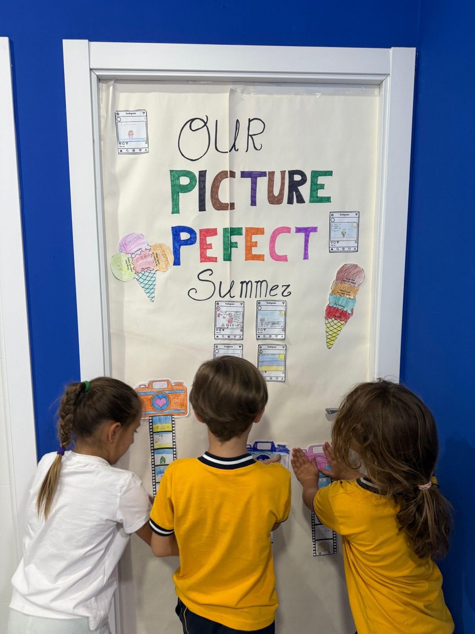 Niños en la academia de inglés Royal English Valdemoro decorando la puerta con el proyecto Our Picture Perfect Summer.