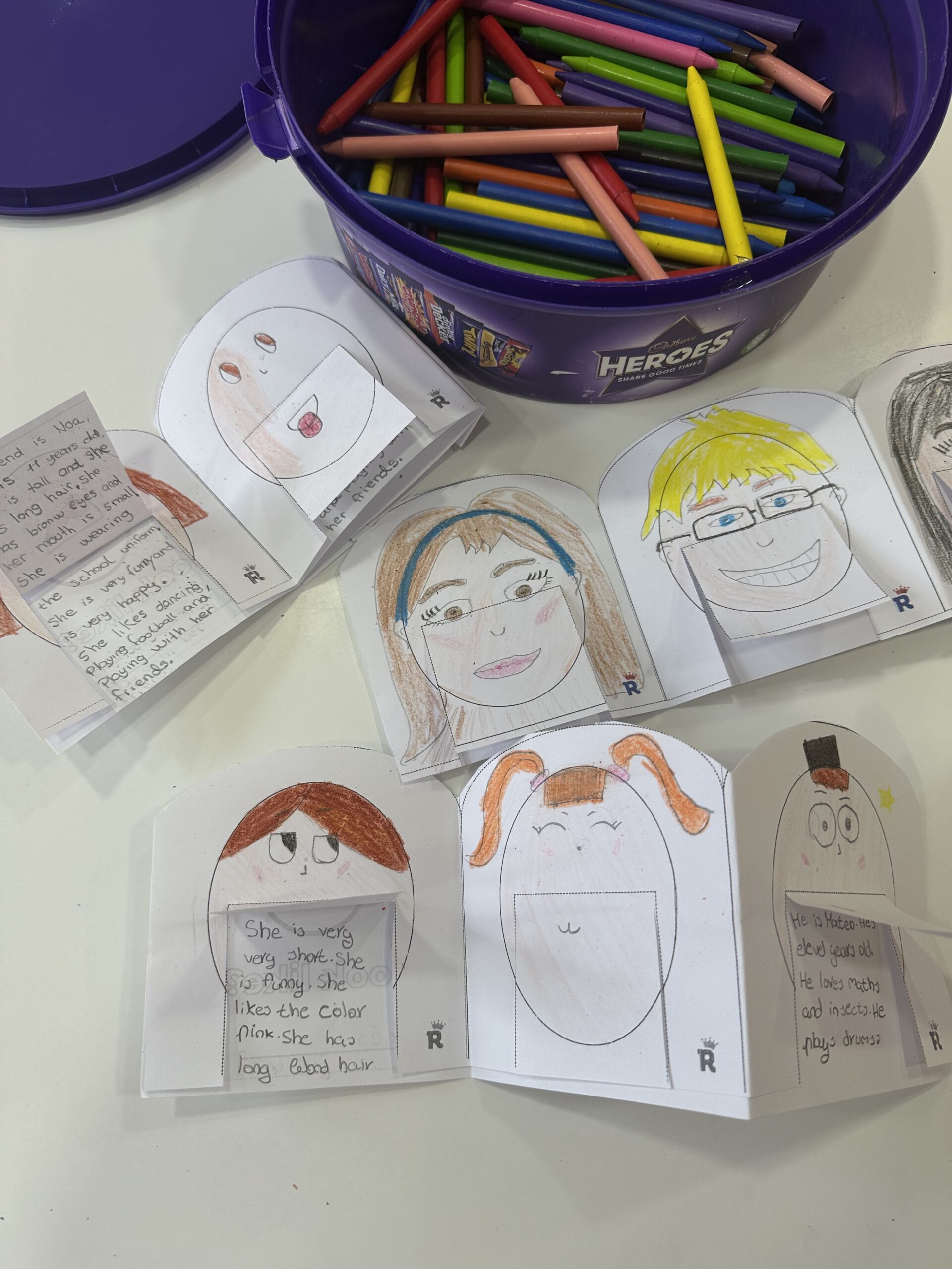 Libritos de descripciones en inglés realizados por los alumnos de la academia Royal English Valdemoro, con dibujos coloreados y textos escritos a mano sobre personas importantes.